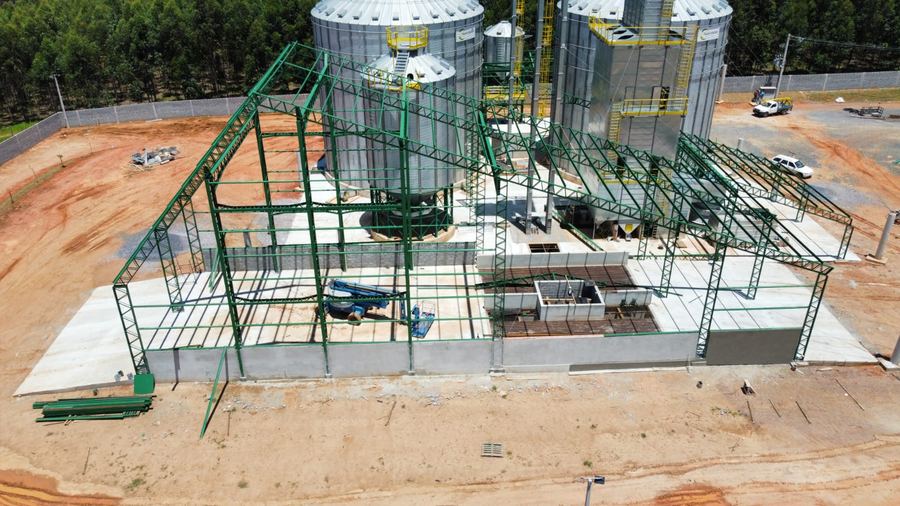 Estrutura metálica em montagem ao lado de silos