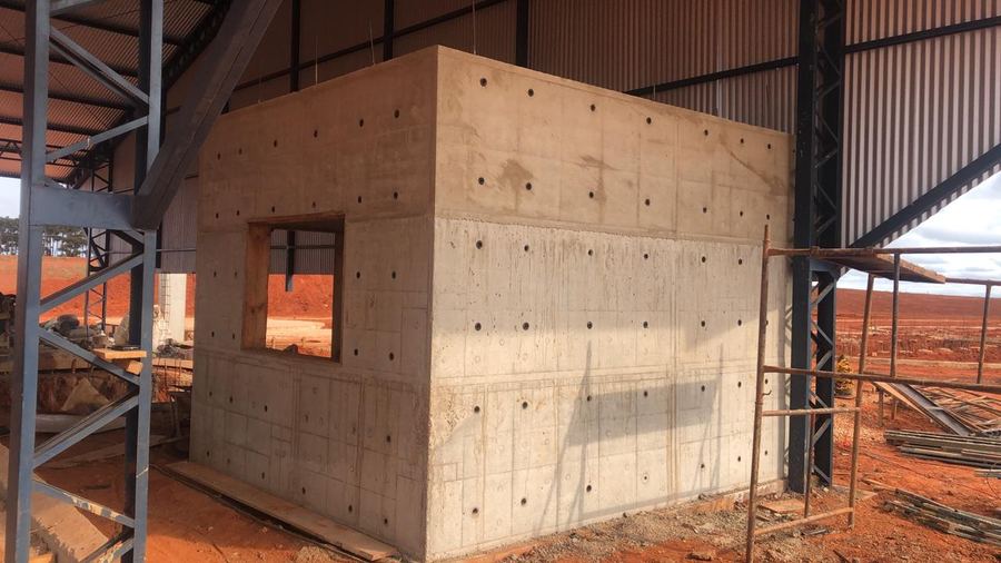 Sala técnica em concreto armado dentro de galpão metálico